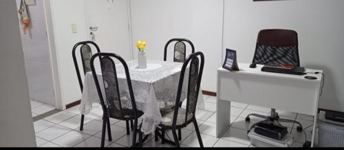 una cocina con mesa con sillas, mesa blanca y mesa de mesa en Quarto privado somente para mulheres e banheiro exclusivos - demais areas compartilhadas, en Maceió