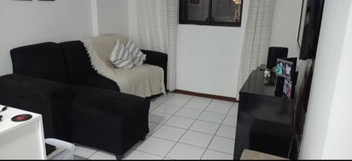 a living room with a couch and a chair at Quarto privado somente para mulheres e banheiro exclusivos - demais areas compartilhadas in Maceió