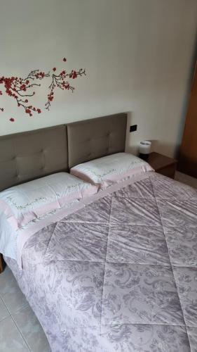 ein Schlafzimmer mit einem großen Bett mit Blumen an der Wand in der Unterkunft Appartamento Vista Panoramica in Agrate Brianza