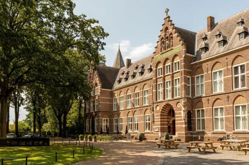 a large brick building with picnic tables in front of it at Bovendonk Business- & Eventlocatie Hoeven in Hoeven