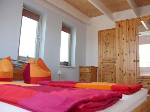 a bedroom with two beds with colorful sheets and windows at Chudzik Modern retreat in Rerik
