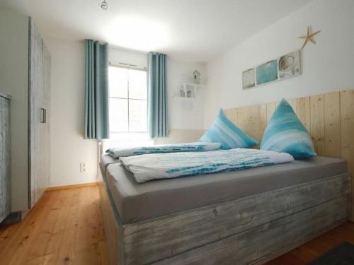 a bedroom with a bed with blue pillows on it at Lüerßen on Uferstrasse in Steinhude