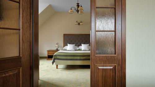 1 dormitorio con 1 cama con almohadas blancas en Hotel Pałac Poledno en Poledno