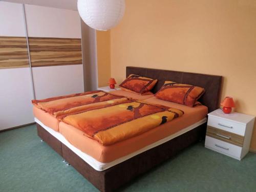 1 dormitorio con 1 cama grande con sábanas y almohadas de color naranja en Bruns Comfortable holiday residence, en Goslar