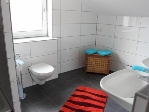 Baño blanco con aseo y lavamanos en Apartment "Max & Moritz", en Bammental