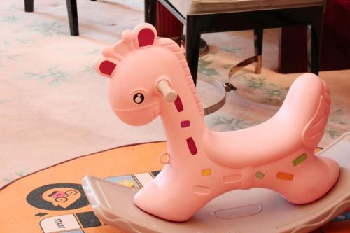 a pink plastic toy giraffe sitting on a table at Ramada Plaza Qiandeng Kunshan in Kunshan