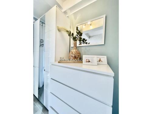 a bathroom with white drawers and a mirror at HOMELIKESTAY unique piece in Wernigerode