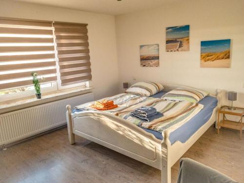 uma cama num quarto com uma janela e uma cama sidx sidx em Borkum Freedom 2 em Borkum