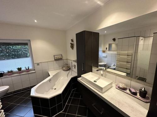 a large bathroom with a tub and a sink at Milan Modern Retreat in Xanten