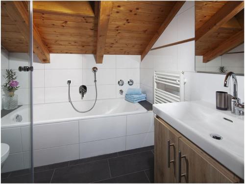 y baño con bañera y lavamanos. en Angerer-the holiday apartment, en Berchtesgaden