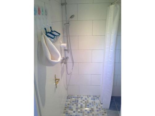 uma casa de banho com chuveiro e piso em azulejo em in the Fischer house Lütje Stuv em Juist