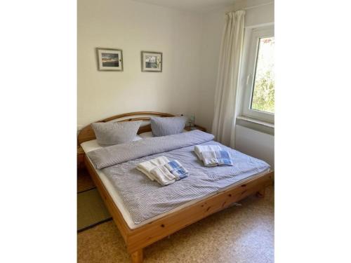 ein Schlafzimmer mit einem Bett mit zwei Kissen darauf in der Unterkunft in the Fischer house Lütje Stuv in Juist