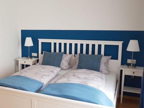 a large bed with blue and white sheets and pillows at Palatinate Forest Comfortable holiday residence in Silz