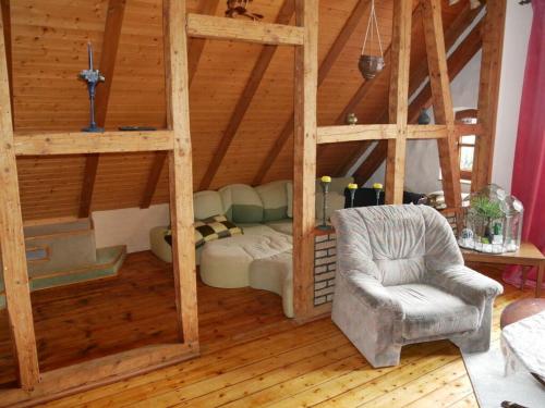 - un salon avec une chaise et un canapé dans l'établissement Former village school, à Stockhausen-Illfurth