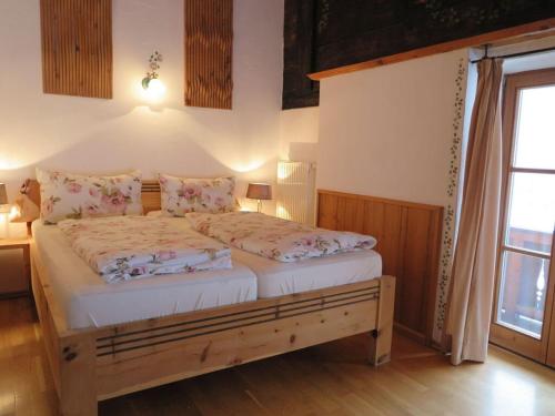 1 dormitorio con 1 cama en una habitación con ventana en Nagelsmederij in het huis Waldwinkel en Aschau im Chiemgau