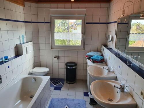 y baño con 2 lavabos, bañera y aseo. en Wutachtal Modern retreat 