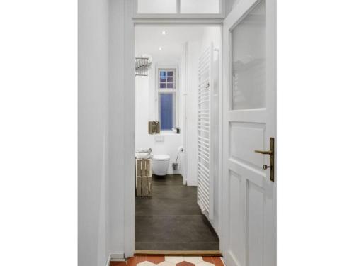 a hallway with a bathroom with a toilet and a door at in the Blue House - ground floor in Garmisch-Partenkirchen