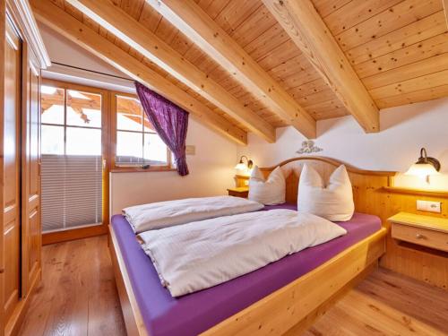 a bed in a room with a wooden ceiling at Holiday apartment Zugspitze in Krün