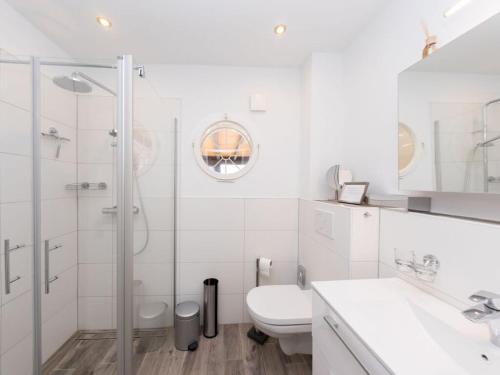 uma casa de banho branca com um chuveiro e um WC. em The Waldhaus Modern retreat em Neerdar