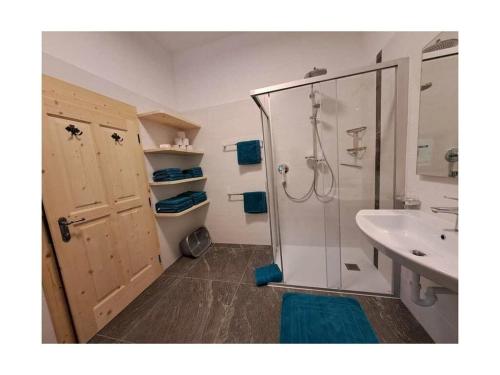 y baño con ducha y lavamanos. en Englhof Modern retreat en Corvara in Passiria