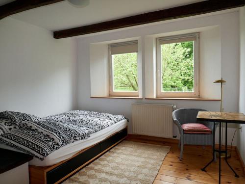 Holperdorp Modern retreat في Lienen: غرفة نوم بسرير ومكتب ونوافذ