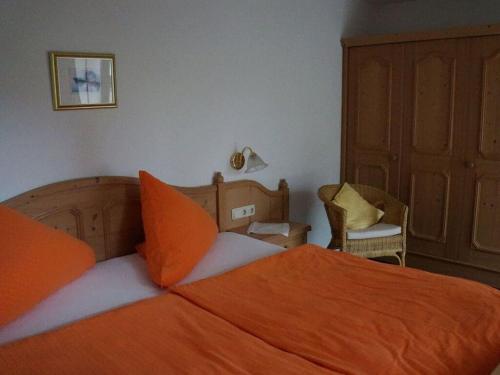 a bedroom with a bed with an orange blanket at Bader Modern retreat in Blaichach
