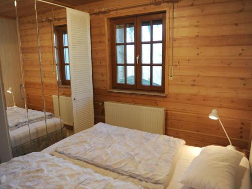 um quarto com uma cama num quarto com paredes de madeira em Panorama Modern retreat em Hilders