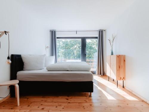 1 dormitorio con cama y ventana grande en Granetal Quarter apartment Bocksberg, en Goslar