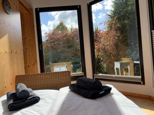 a bedroom with a bed with two black towels on it at Chalet St Lambertus Apartment A in Lambertsberg