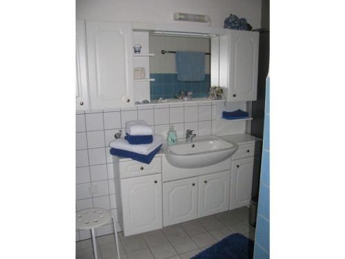 een witte badkamer met een wastafel en een spiegel bij "Am Ahornweg" Modern retreat in Speelberg