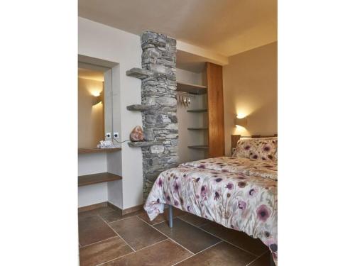 een slaapkamer met een bed en een stenen pilaar bij Via Roma 53 - Bedero in Brezzo