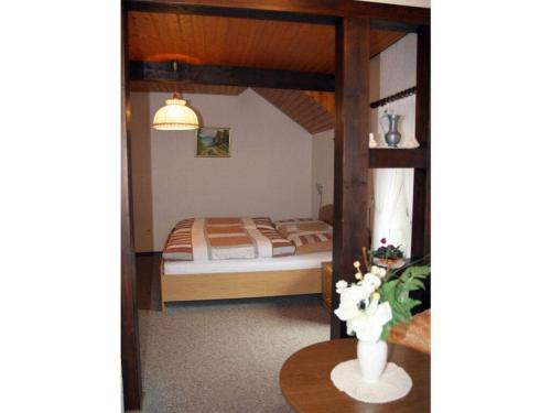 Un dormitorio con una cama y una mesa con un jarrón. en Brown Modern Retreat, en Sankt Aldegund