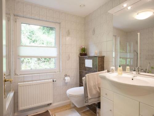 baño con lavabo y aseo y ventana en chez Emil and Isabelle, en Rumbach