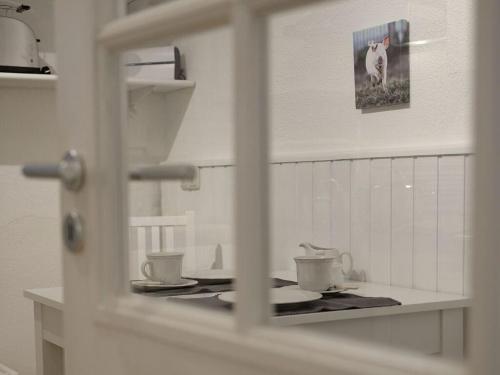 eine Küchentheke mit Tassen und Tellern darauf in der Unterkunft Holiday apartment at Molopark in Murnau am Staffelsee