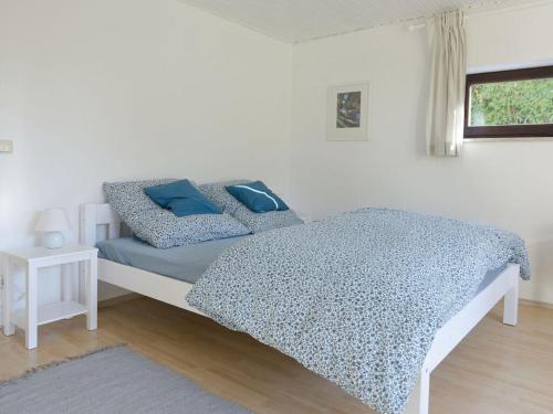 Un dormitorio con una cama con almohadas azules. en Holiday apartment at Molopark, en Murnau am Staffelsee