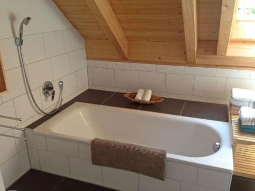 La salle de bains est pourvue d'une baignoire et d'un plafond en bois. dans l'établissement Gaienhofen Modern retreat, à Gaienhofen
