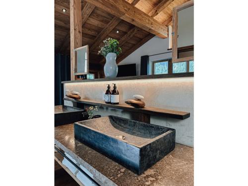 a bathroom with a large stone sink on a counter at Chalet Alpin Modern retreat in Bayrischzell