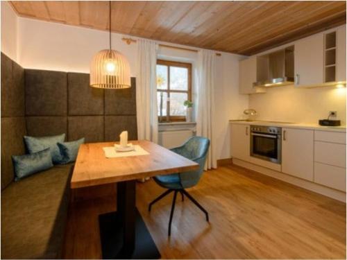 uma cozinha com uma mesa de madeira e uma sala de jantar em Hittenpichl "St Joseph" em Bodenmais