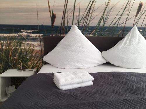 ein Bett mit Handtüchern und Kissen darüber in der Unterkunft Holiday apartment WeserWeitblick in Bremerhaven