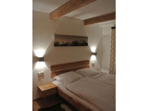a bedroom with a bed with two lights on the wall at Alpenliebe Modern retreat in Reit im Winkl