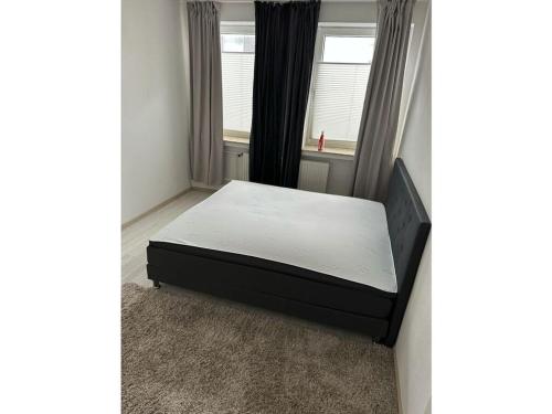 Una cama sentada en una habitación con ventana. en Gießler Comfortable holiday residence, en Bremerhaven