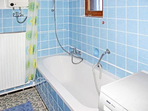 ein blau gefliestes Bad mit einer Badewanne und einer Dusche in der Unterkunft Rappenloch Modern retreat in Eisenbach