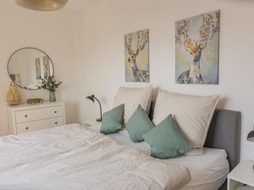 een slaapkamer met een bed met kussens en een spiegel bij Luxury apartment Bad Salzuflen in Bad Salzuflen