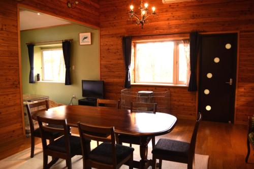 a dining room with a wooden table and chairs at Sasamori House in Azumino