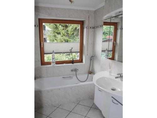 biała łazienka z wanną i umywalką w obiekcie Valley station Modern retreat w Garmisch Partenkirchen