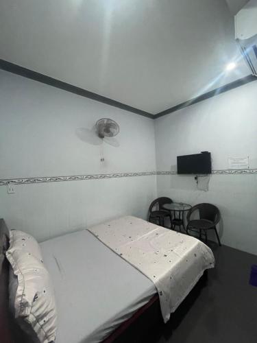 Habitación hospitalaria con cama y TV en Nhà nghỉ Trà My, en Ấp Lò Vôi