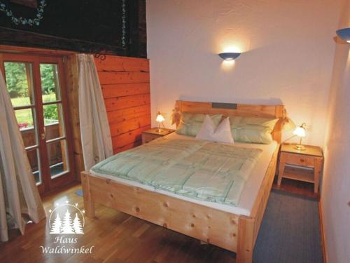 ein Schlafzimmer mit einem großen Holzbett mit zwei Tischen in der Unterkunft Waterval in het huis Boshoek in Aschau im Chiemgau