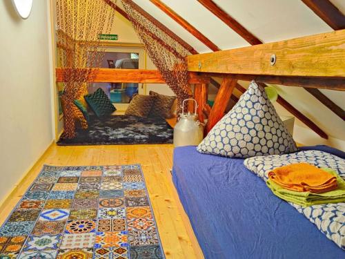 a attic room with a bed and a rug at Cheese kitchen Bernbeuren in Bernbeuren