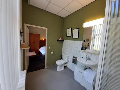 a bathroom with a toilet and a sink at Conferentiecentrum Hotel Bovendonk in Hoeven