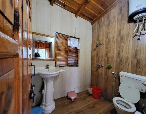 a bathroom with a sink and a toilet and a sink at Hartola Panorama Homestay in Rāmgarh